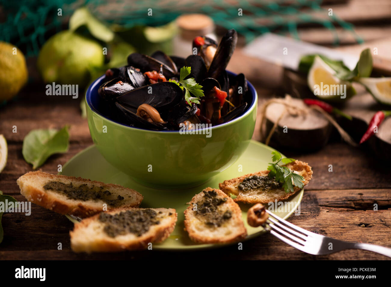 Mejillones hervidos en plato de cocina sobre fondo de madera Foto de stock