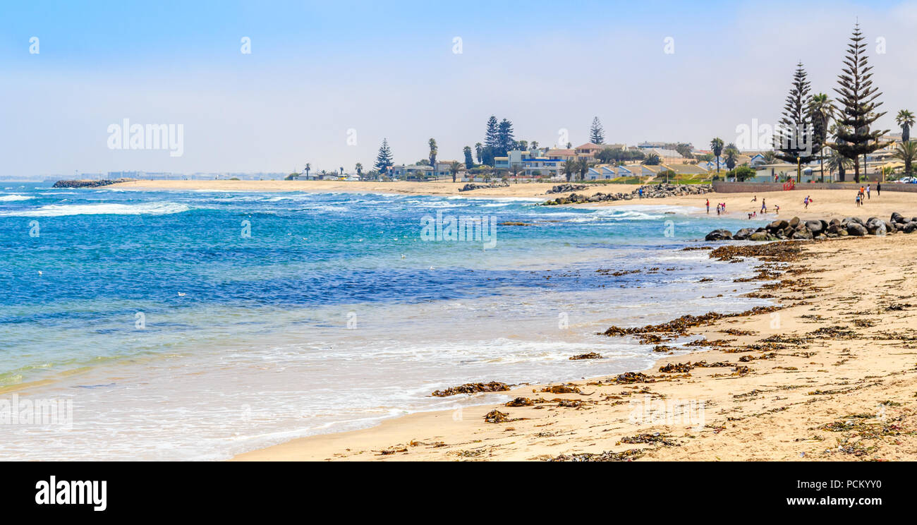 Océano Azul, costa arenosa y casas de Swakopmund, ciudad colonial alemana Namibia Foto de stock