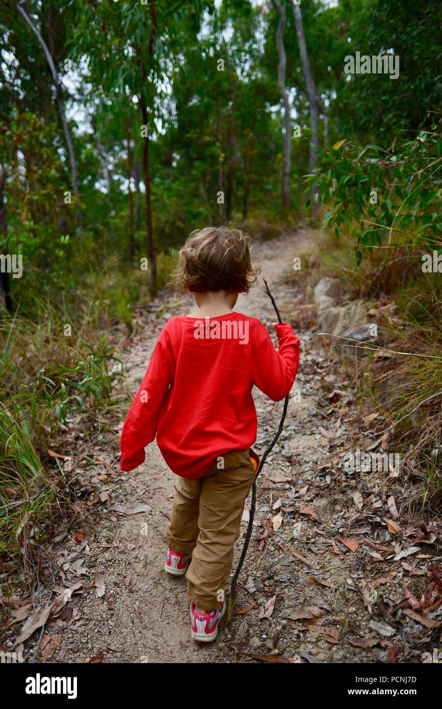 Los niños caminando a través de un bosque, Cardwell, Queensland, Australia Foto de stock