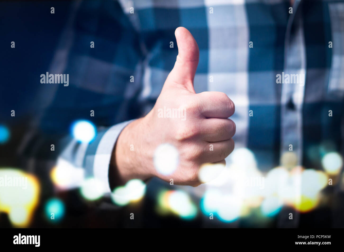 Hombre mostrando Thumbs up en espacios modernos y abstractos. Persona de negocios feliz dando satisfecho y solidario gesto de mano. Foto de stock