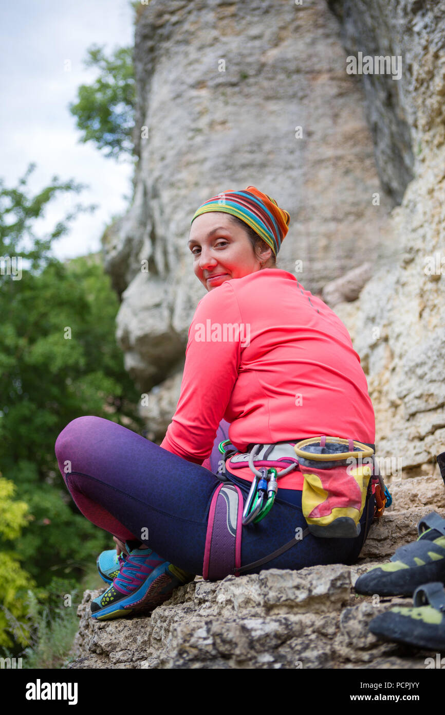 Foto de la parte posterior de la mujer sonriente escalada mujer sentada  junto a la montaña Fotografía de stock - Alamy