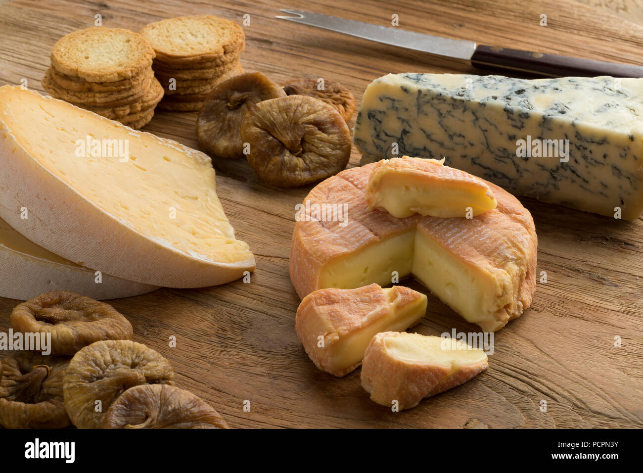 Tabla de quesos con una gran variedad de quesos, higos secos y tostadas y de postre Foto de stock
