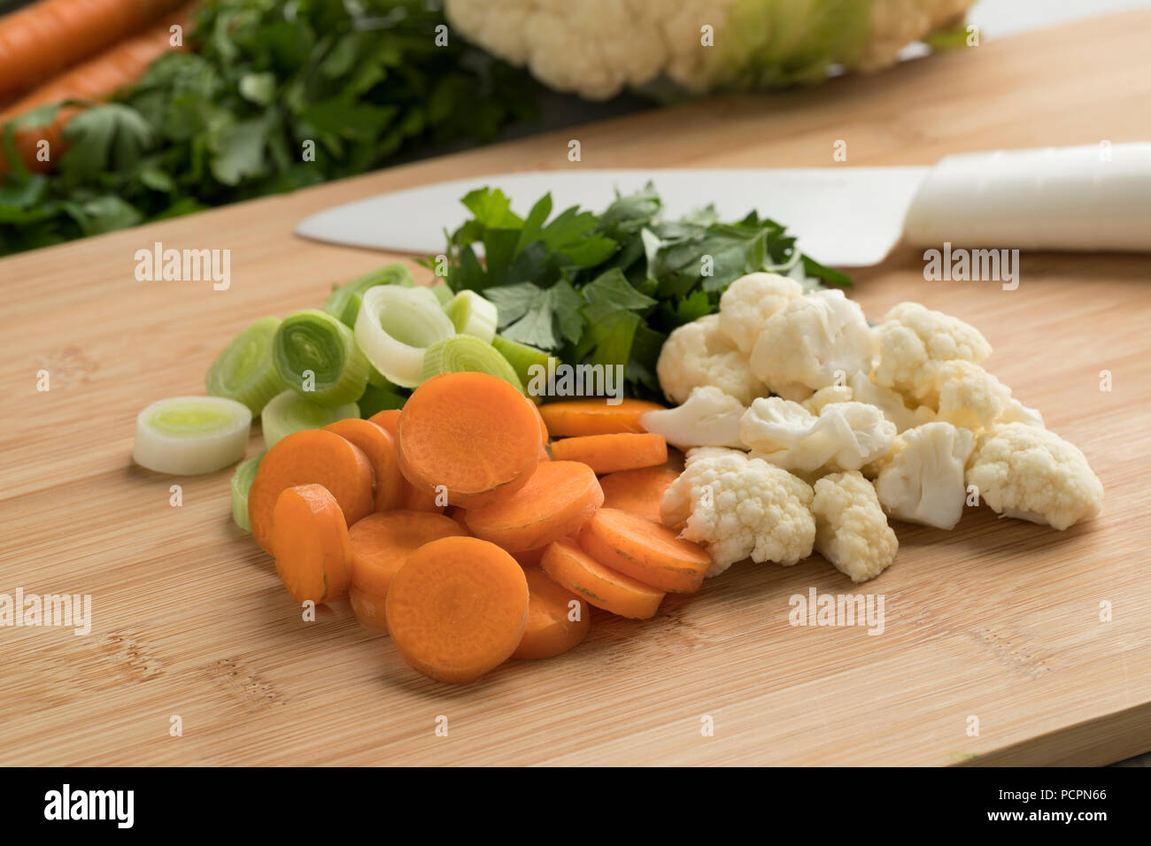 Verduras orgánicas frescas cortadas sobre una tabla para cortar Foto de stock