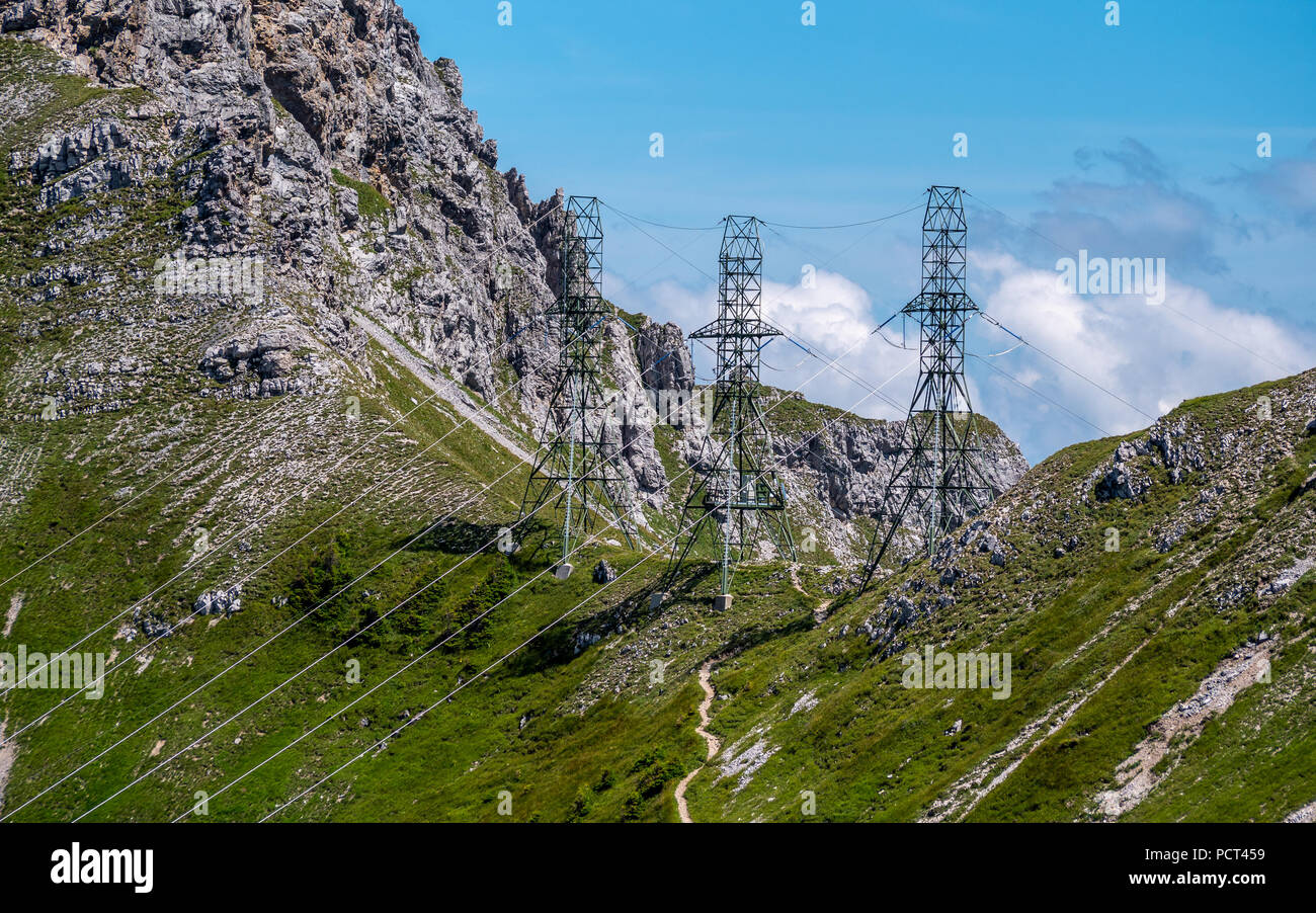 Poste de alta tensión tres postes de electricidad en las altas montañas de los Alpes de Suiza torre de alta tensión Foto de stock