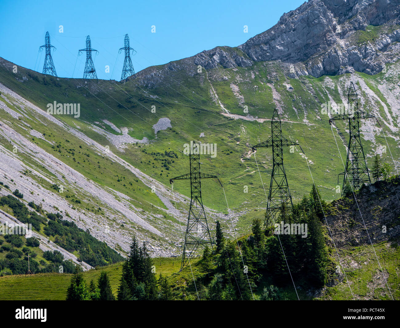 Poste de alta tensión tres postes de electricidad en las montañas empinadas torres de alta tensión Suiza Alpes Foto de stock