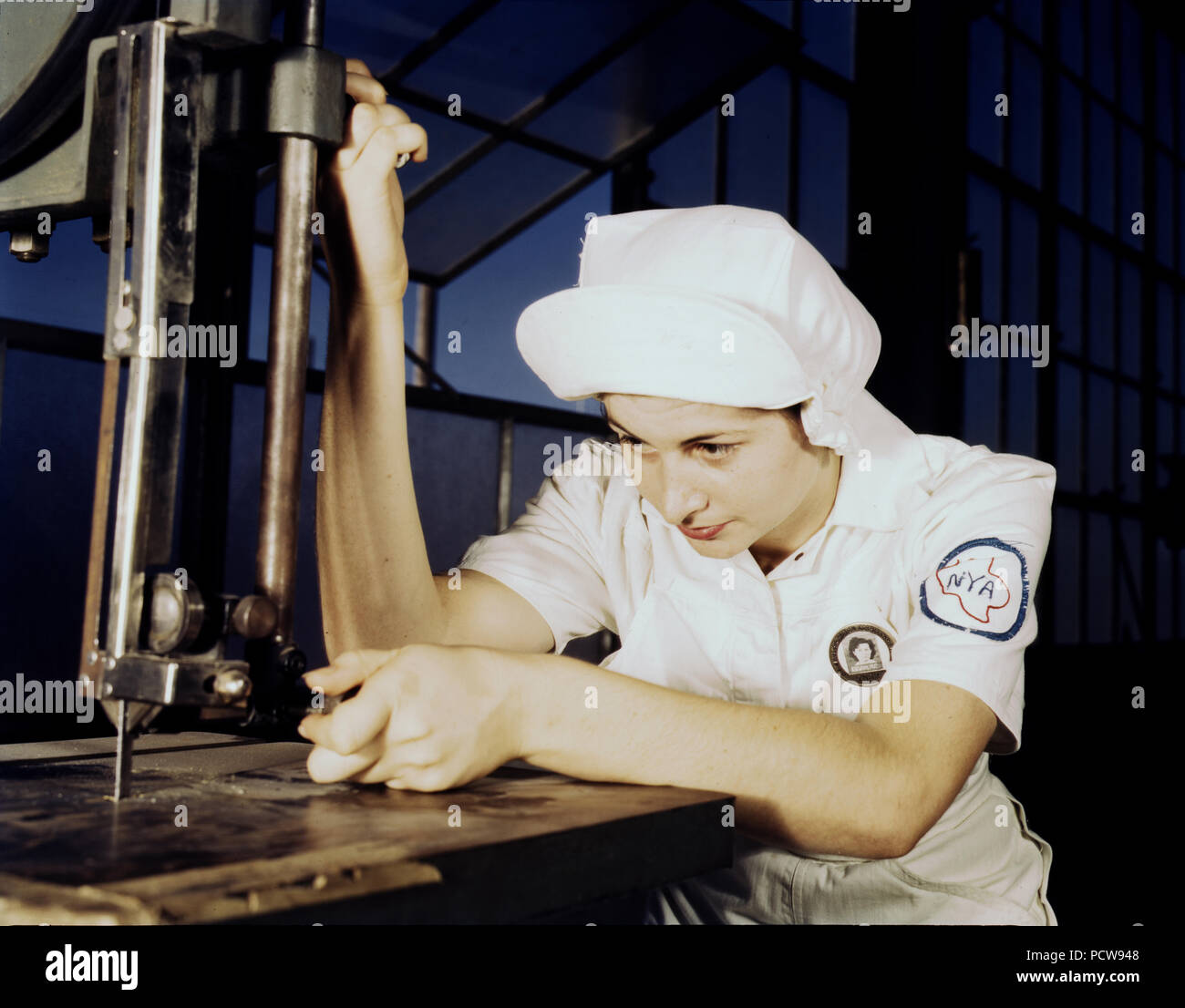 "Damas de Blanco" médico (motores de aviones de la Marina) en la Base Aérea Naval, Corpus Christi, Texas. Aquí, un NYA cursillista en la base, está aprendiendo a operar una máquina de cortar en el Departamento de montaje y reparación. Agosto de 1942 Foto de stock