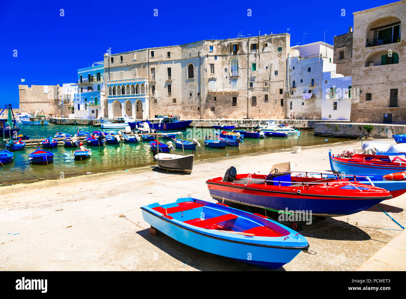 Hermosa ciudad de Monopoli,ver con barcos de pesca tradicionales y casas, Puglia, Italia. Foto de stock