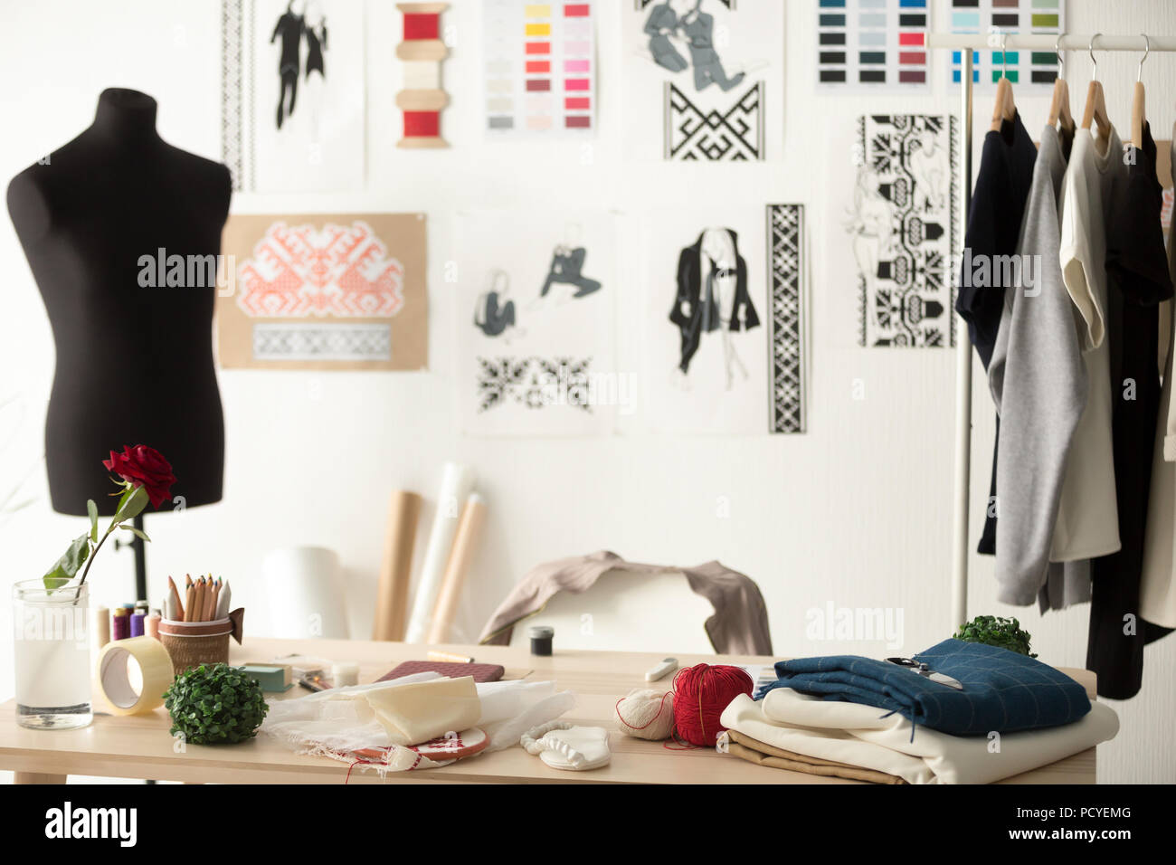 Diseñador de moda showroom con maniquí, escritorio de trabajo y ropa Foto de stock