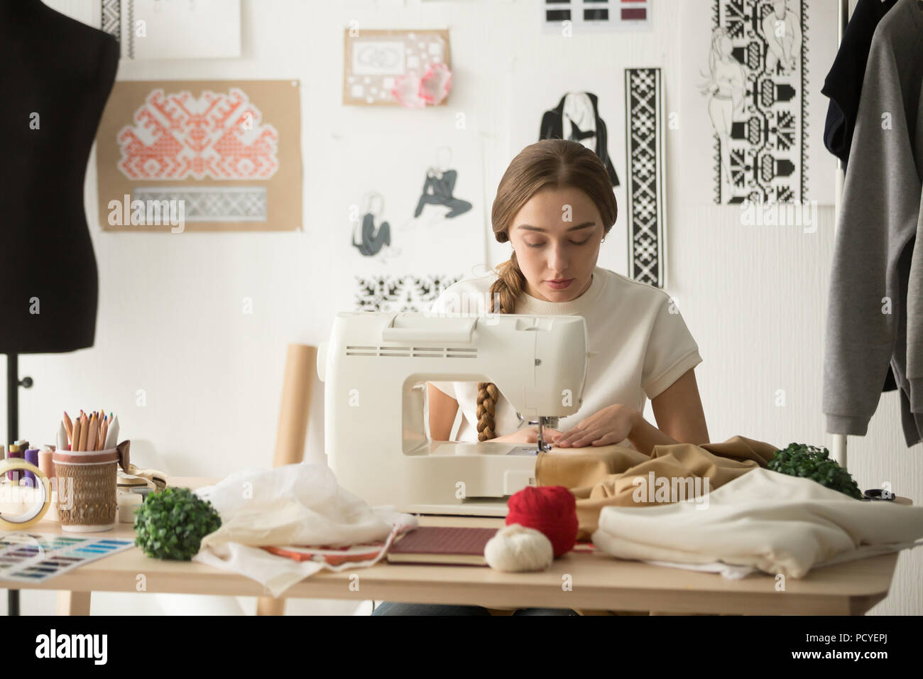 A medida femenina costura en máquina de coser en design studio Foto de stock