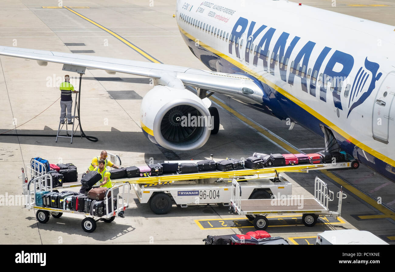 Los manipuladores de equipaje bolsas de carga en la bodega de un avión de el aeropuerto de Faro en Portugal Fotografía de stock -