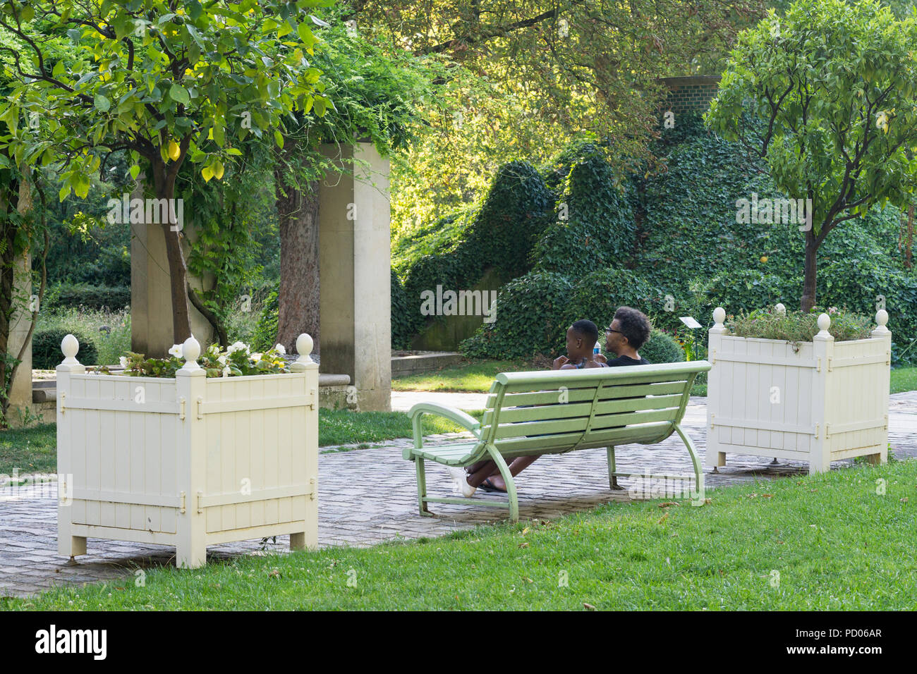 Parque de París - negro par charlando en un banco en el Parque de Bercy, en el 12º arrondissement de París, Francia, Europa. Foto de stock