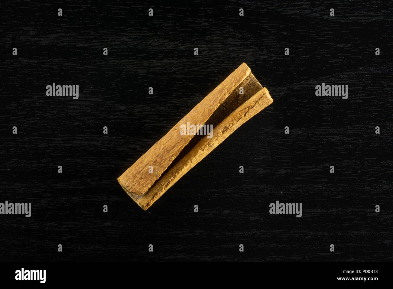 Toda una rama de canela flatlay marrón seco en madera color negro  Fotografía de stock - Alamy