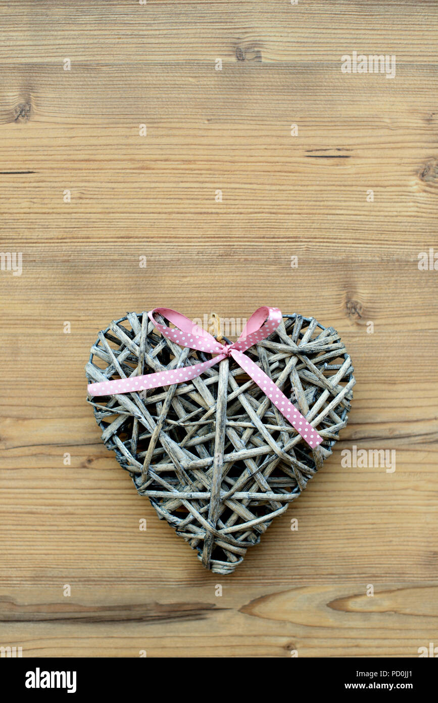 Paja decorativa hecha a mano y corazón de paja, sobre fondo de madera