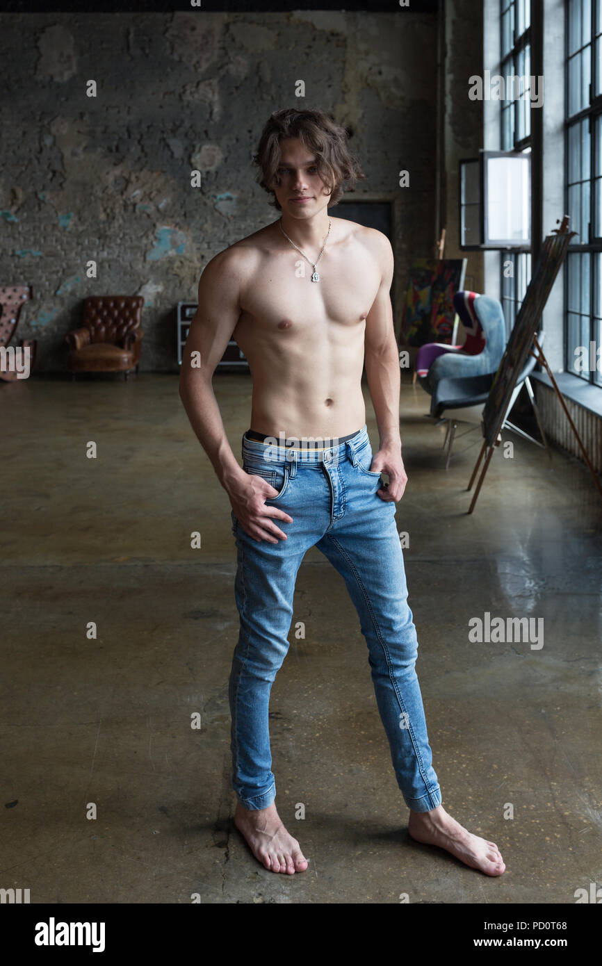 Rubio guapo modelo masculino con ojos azules posando de cuerpo completo en  interiores Fotografía de stock - Alamy