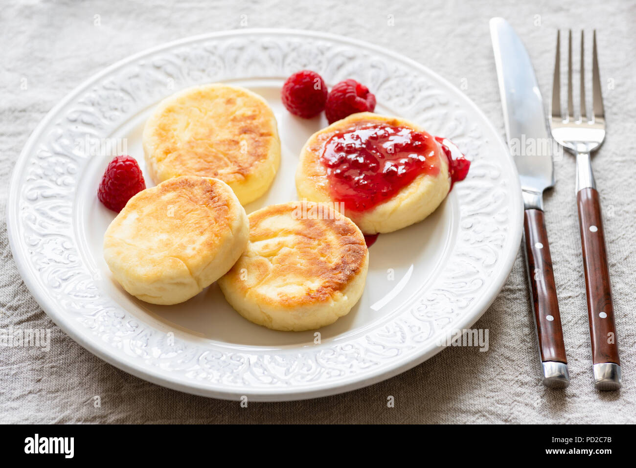 Requesón panqueques o syrniki con mermelada en la placa blanca. Desayuno dulce alimento. Cocina ruso o ucraniano Foto de stock