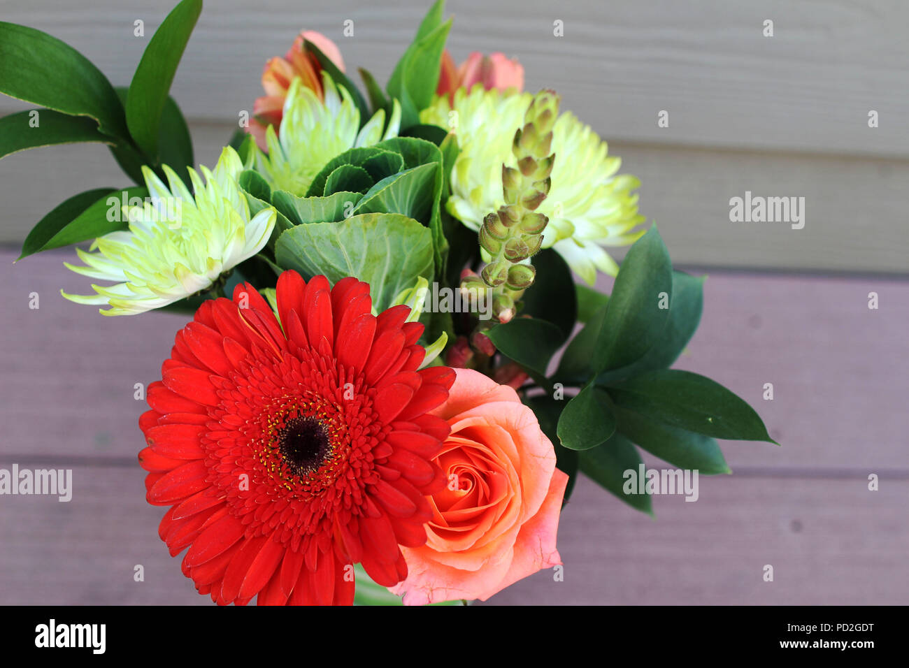 Vista superior de un pequeño ramo de flores coloridas sobre un fondo de madera. La fotografía de modos de vida, cerrar Foto de stock