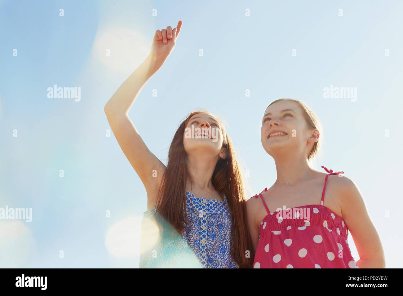 Mejores amigos apuntando hacia arriba y mirando al cielo Foto de stock