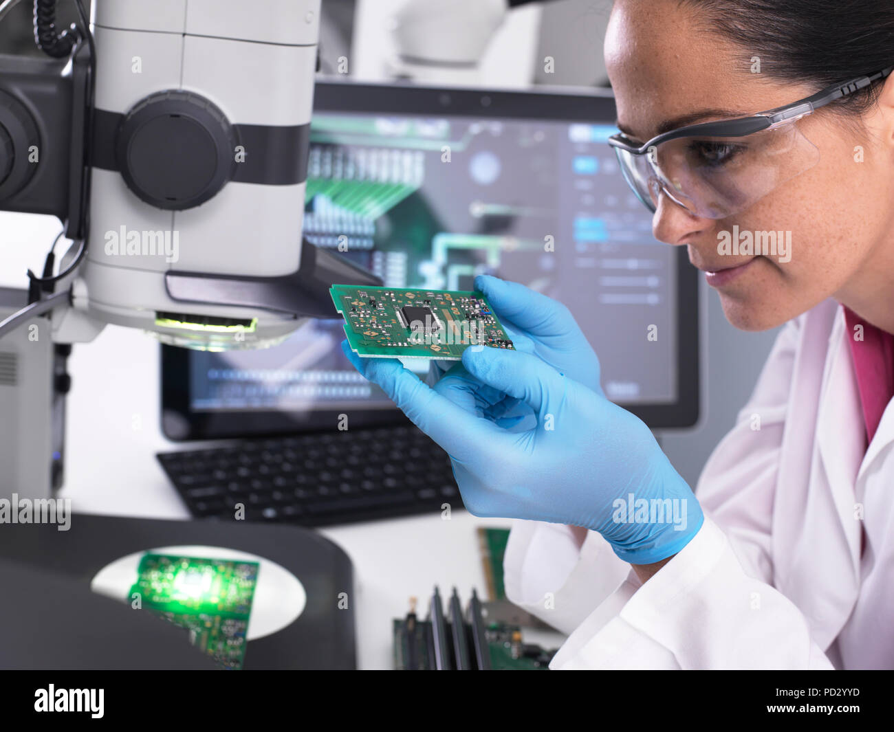 Ingeniero servo 3D utilizando microscopio para ver la precisión dimensional de manufacturas de montaje en PCB Foto de stock