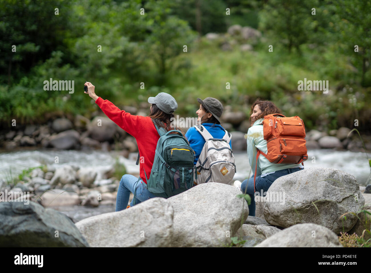 Grupo de mujeres amigas Backpacker disfrutar de Viaje en carretera y teniendo selfie en el bosque en el fin de semana de verano - Estilo de vida y concepto de recreación. Foto de stock
