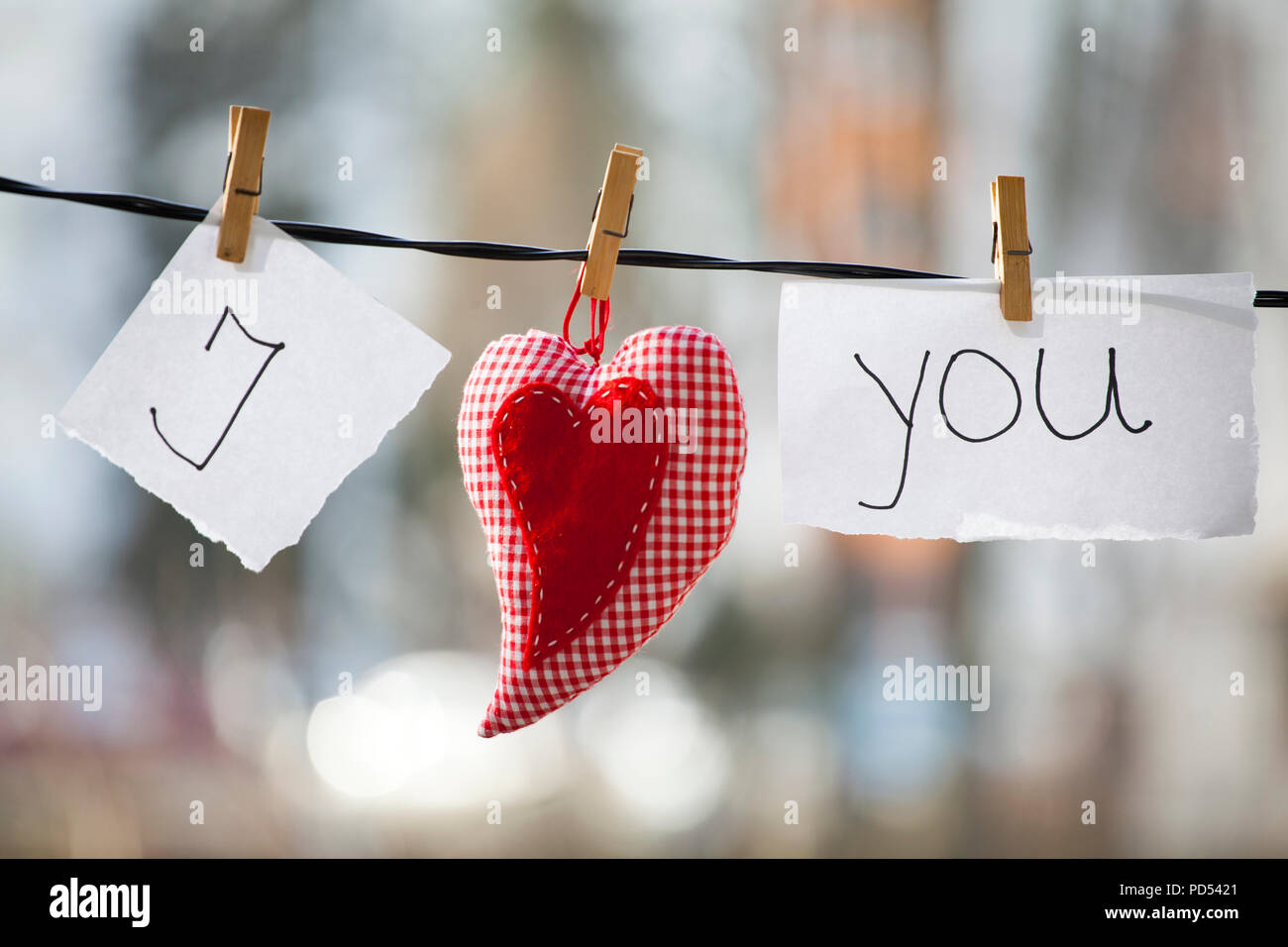 I Love You de fondo. El corazón y la nota con las palabras "I Love You"  colgando de un tendedero Fotografía de stock - Alamy