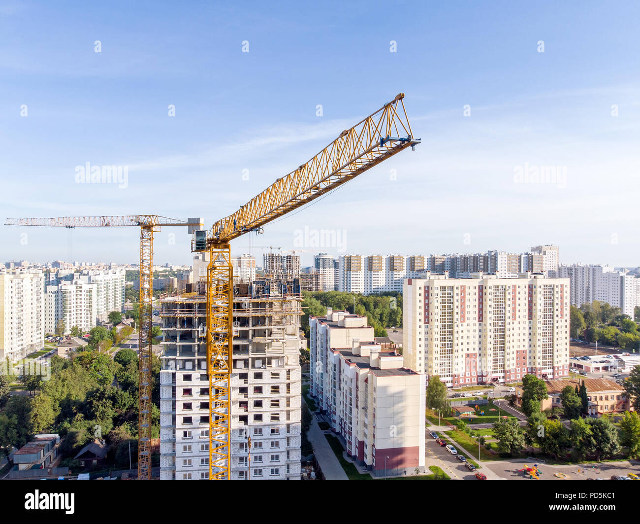 Alta amarillo grúa torre cerca multistorey apartamento en construcción. Fotografía aérea Foto de stock