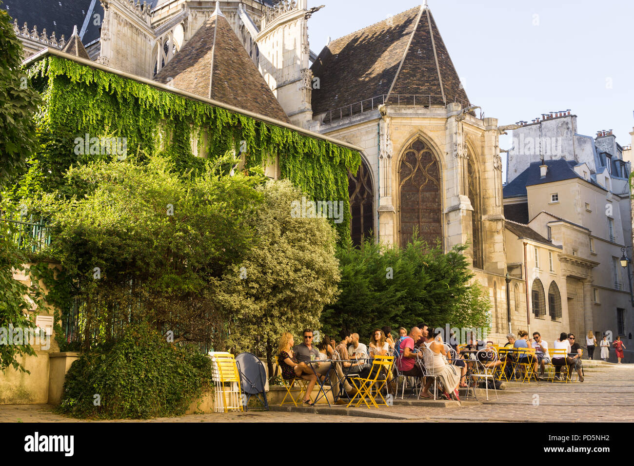Café de Paris Marais street scene - personas chateando en un café en la Rue des Barres en la sombra de la iglesia de Saint Gervais en París, Francia, Europa. Foto de stock