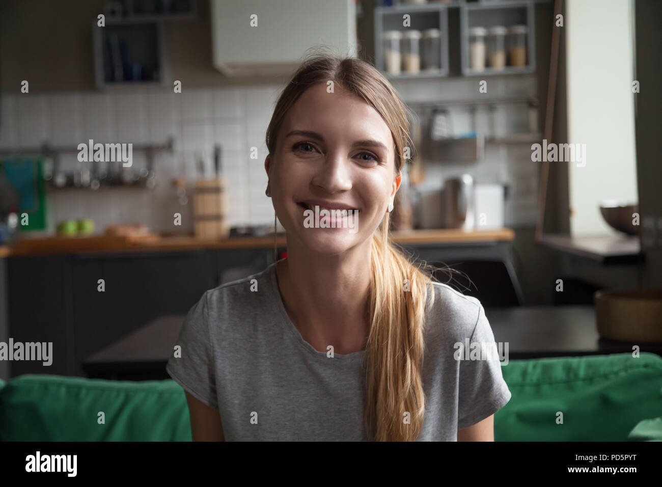 Mujer sonriente hablando por videocall dating online mirando vino Foto de stock