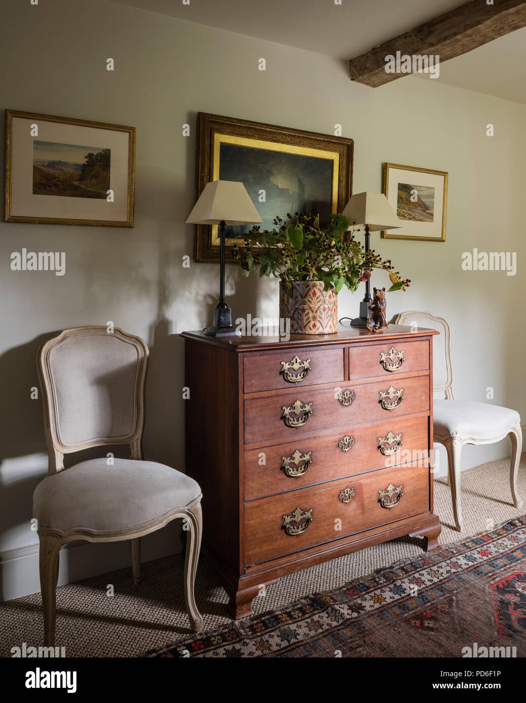 Vintage de madera cajonera con pinturas y sillas Fotografía de stock - Alamy