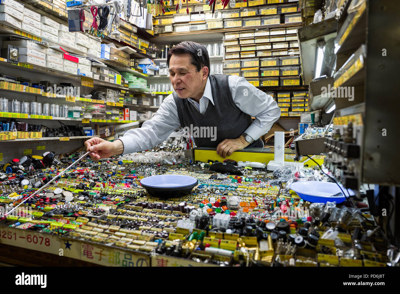 La isla de Japón, Honshu, Kanto, Tokio, un vendedor en una pequeña boutique de componentes electrónicos. Foto de stock
