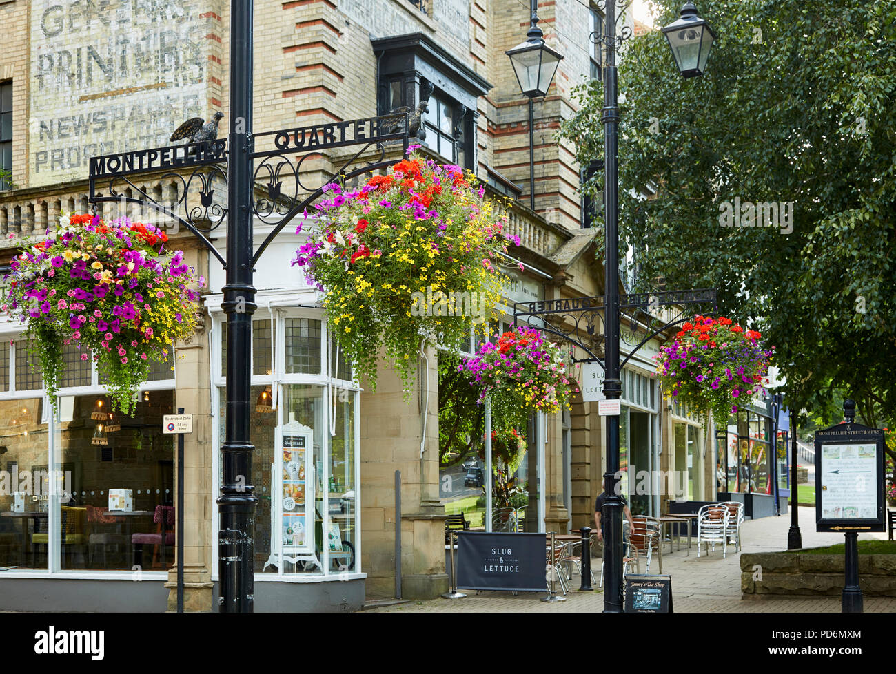 Montpellier Trimestre, Harrogate con farolas de hierro fundido y cestas colgantes florales encantadora en un ambiente elegante y cosmopolita, el área de compras. Foto de stock