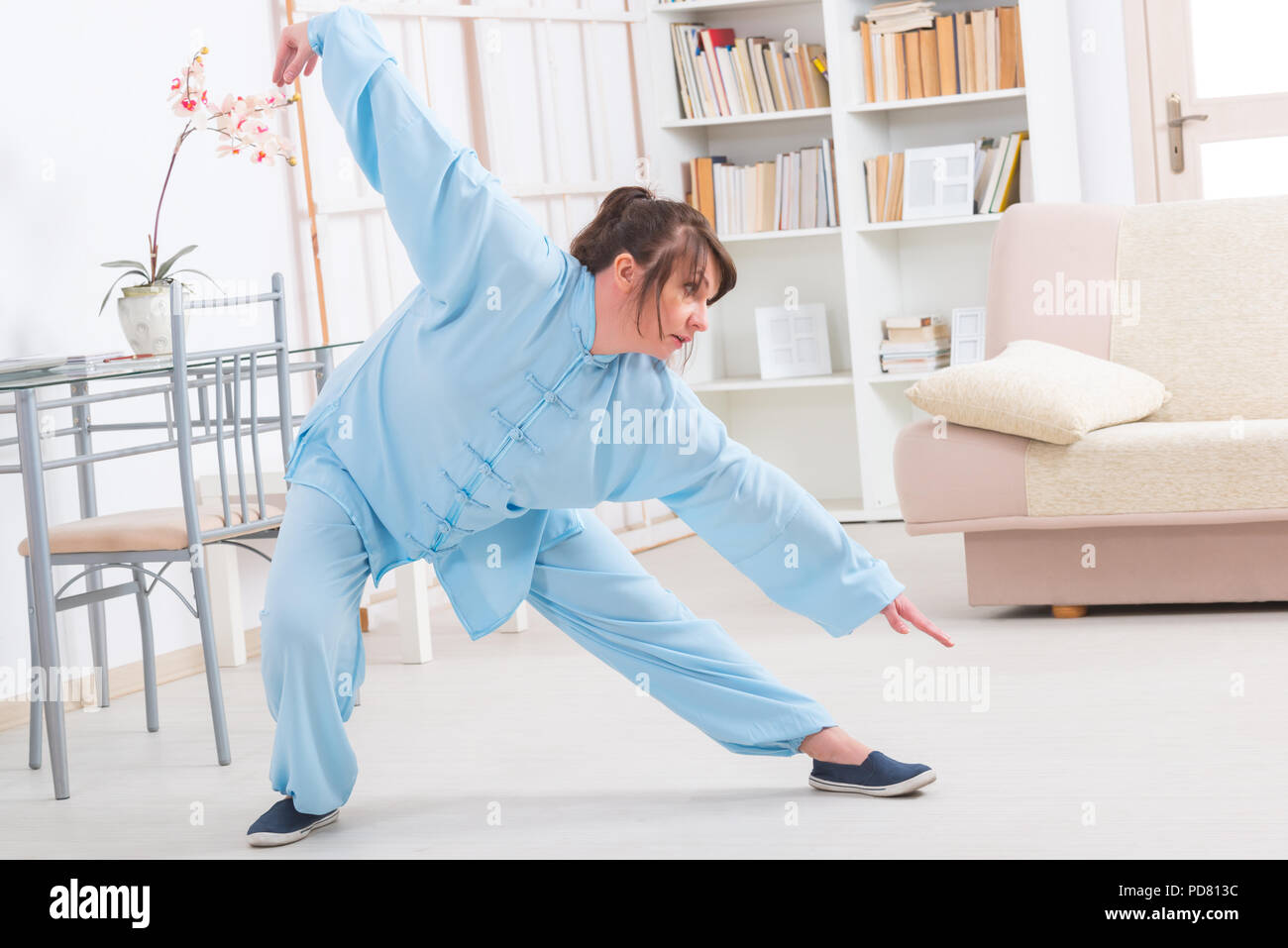 Bella mujer haciendo ejercicios de tai chi qi gong o reiki vistiendo ropa  original chino profesional en casa Fotografía de stock - Alamy