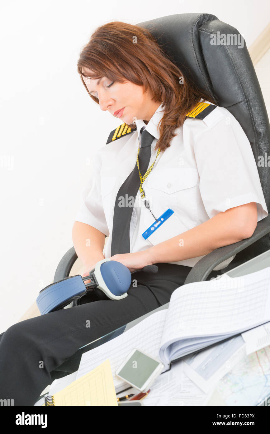 Sobrecargado de trabajo, mujer piloto uniforme con charreteras descansando  o durmiendo en la sala de información Fotografía de stock - Alamy