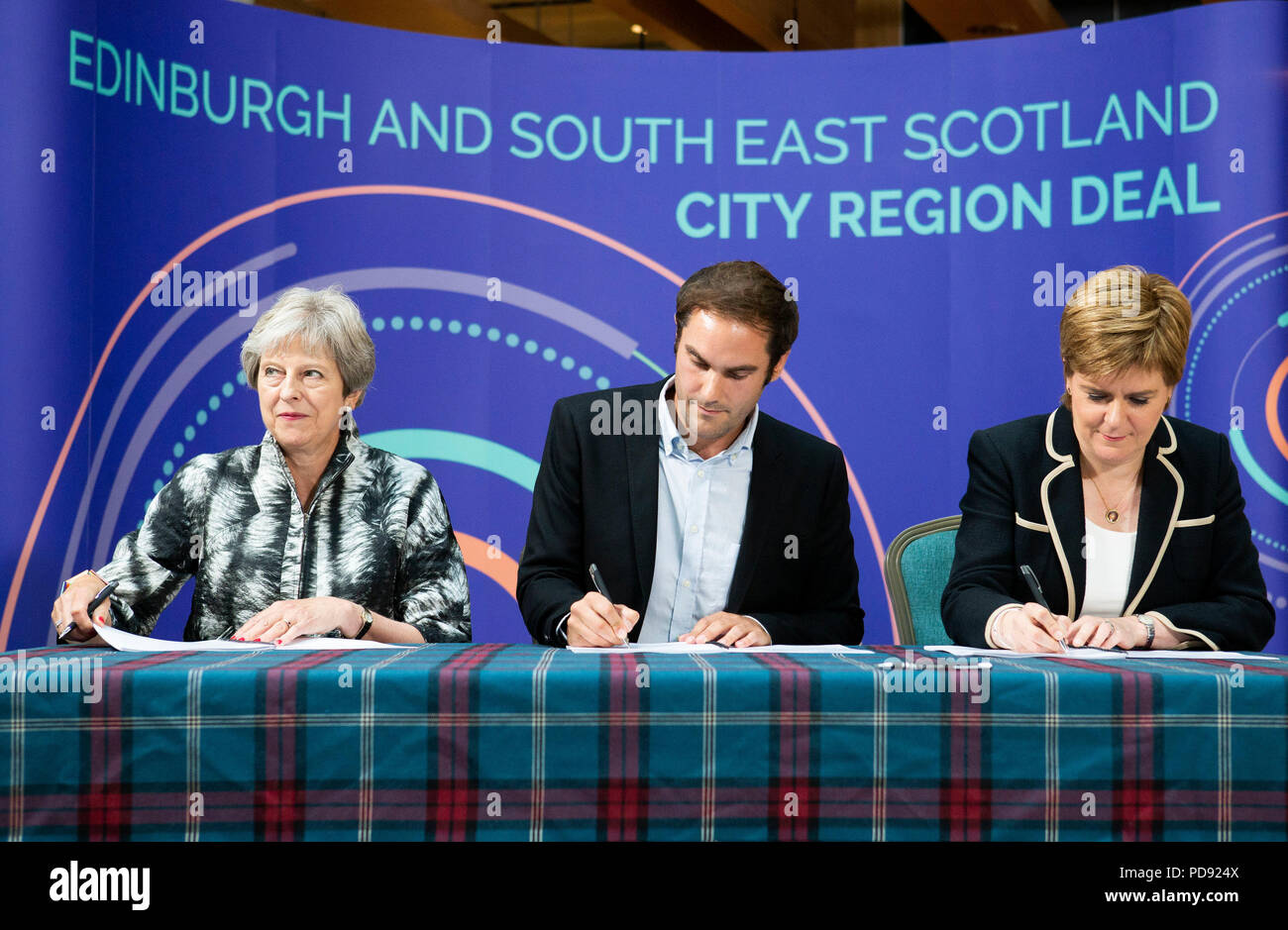 El Primer Ministro Teresa Mayo, dirigente del consejo de ciudad de Edimburgo Adam McVey y Primer Ministro Nicola Sturgeon firmar el Edimburgo y Escocia región del sudeste de la ciudad frente a la Universidad de Edimburgo, Edimburgo. Foto de stock