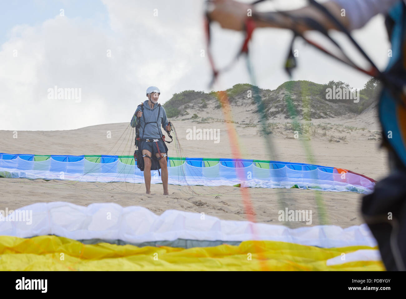 Macho parapente con paracaídas en la playa Foto de stock