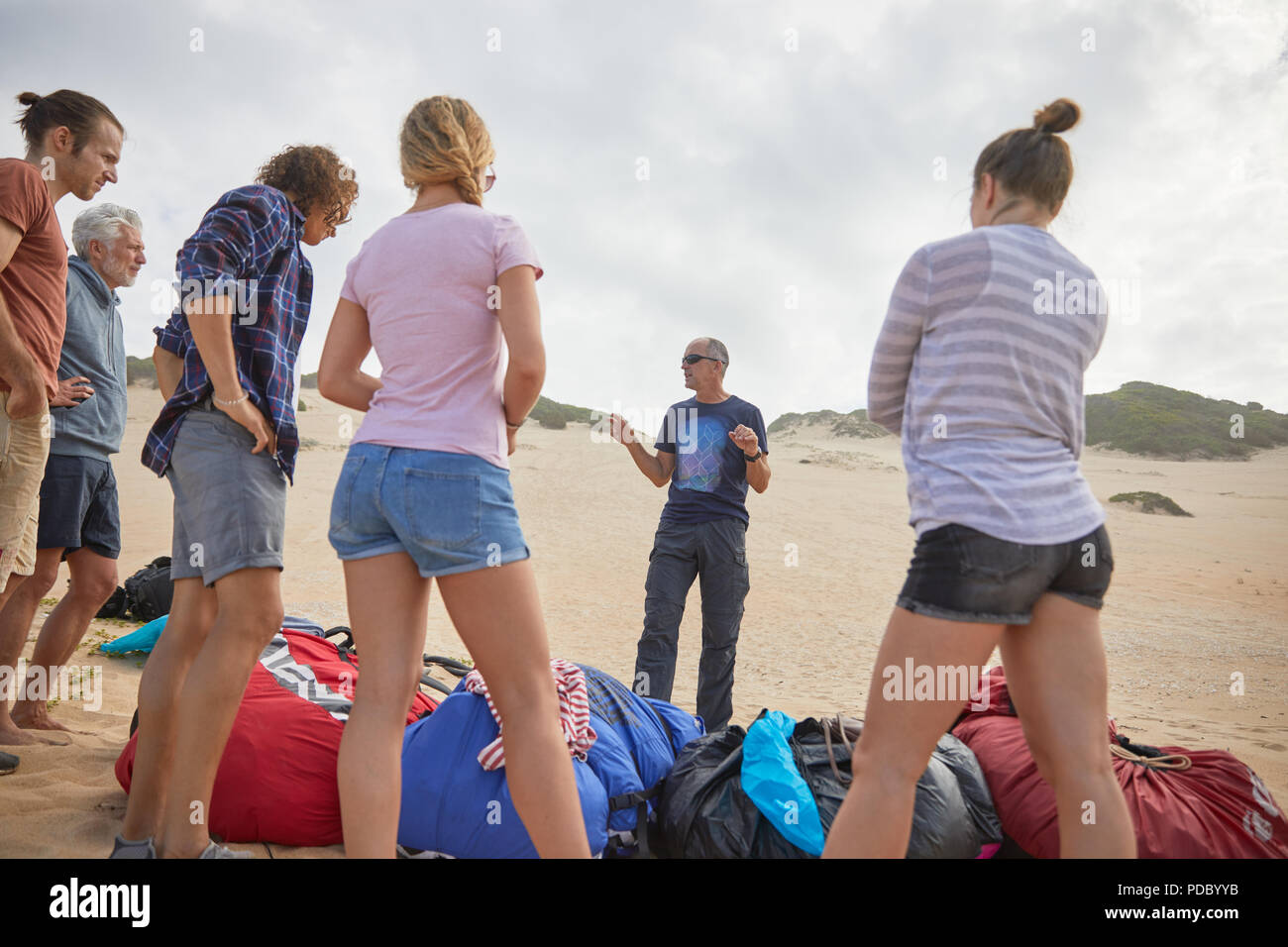 Instructor de Parapente macho hablando a los estudiantes en la playa Foto de stock