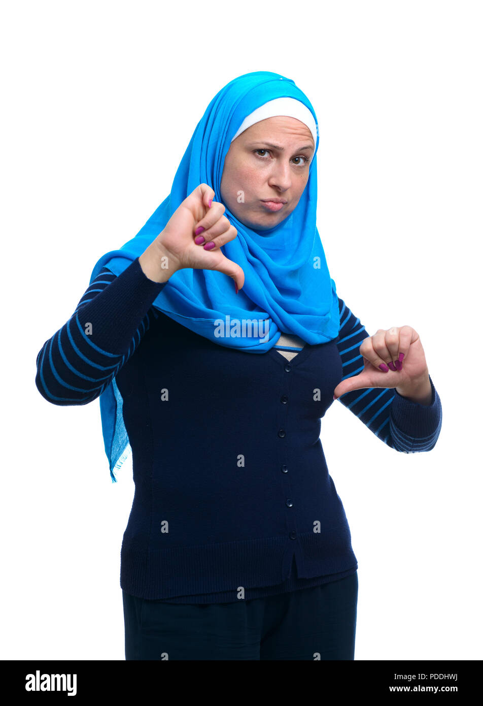 Hermosa mujer musulmana moderna con los pulgares hacia abajo aislado sobre fondo blanco. Foto de stock