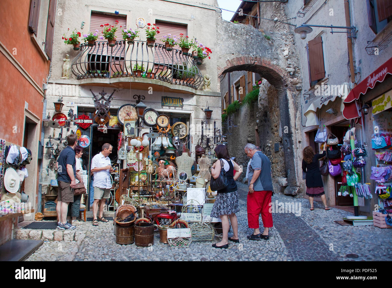 Los turistas en una tienda de souvenirs, antigua ciudad de Malcesine, provincia de Verona, Lago de Garda, Lombardía, Italia Foto de stock