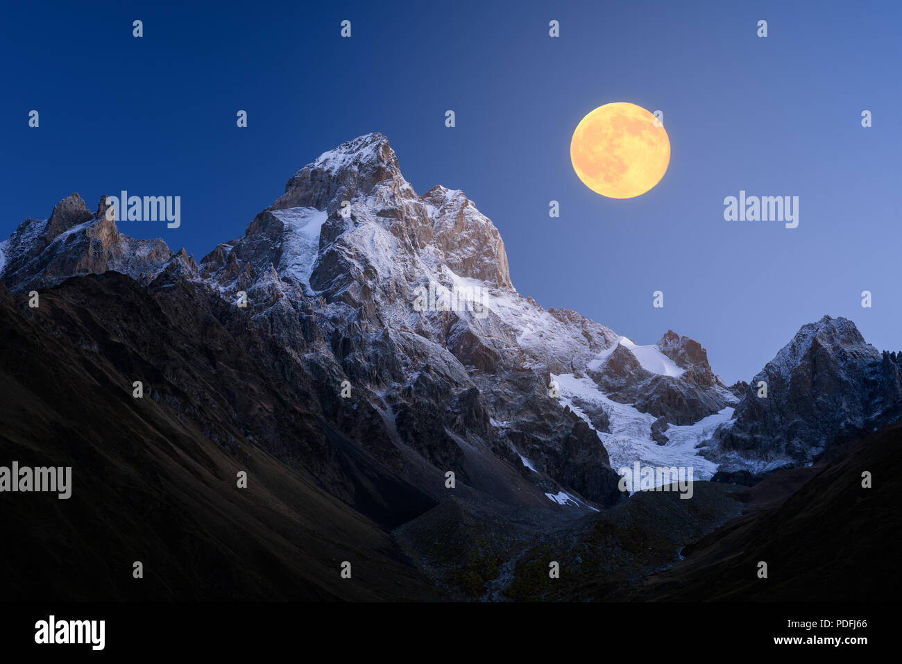 Ushba es el pico de la montaña del Cáucaso. Paisaje nocturno con luna llena sobre Ridge. Svaneti, Georgia Foto de stock