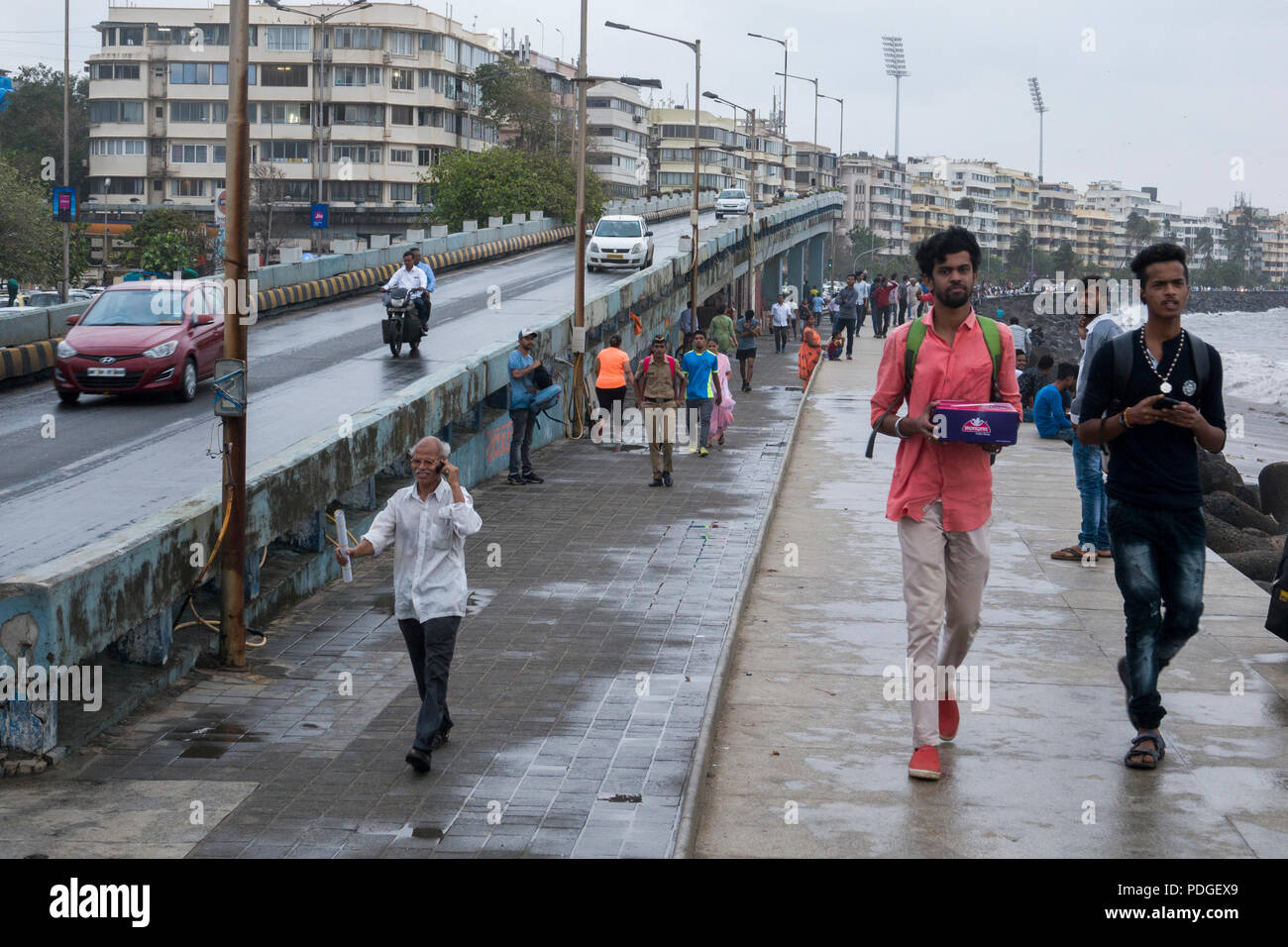 La gente en Marine Drive promenade durante la temporada de monzones en Mumbai, India Foto de stock