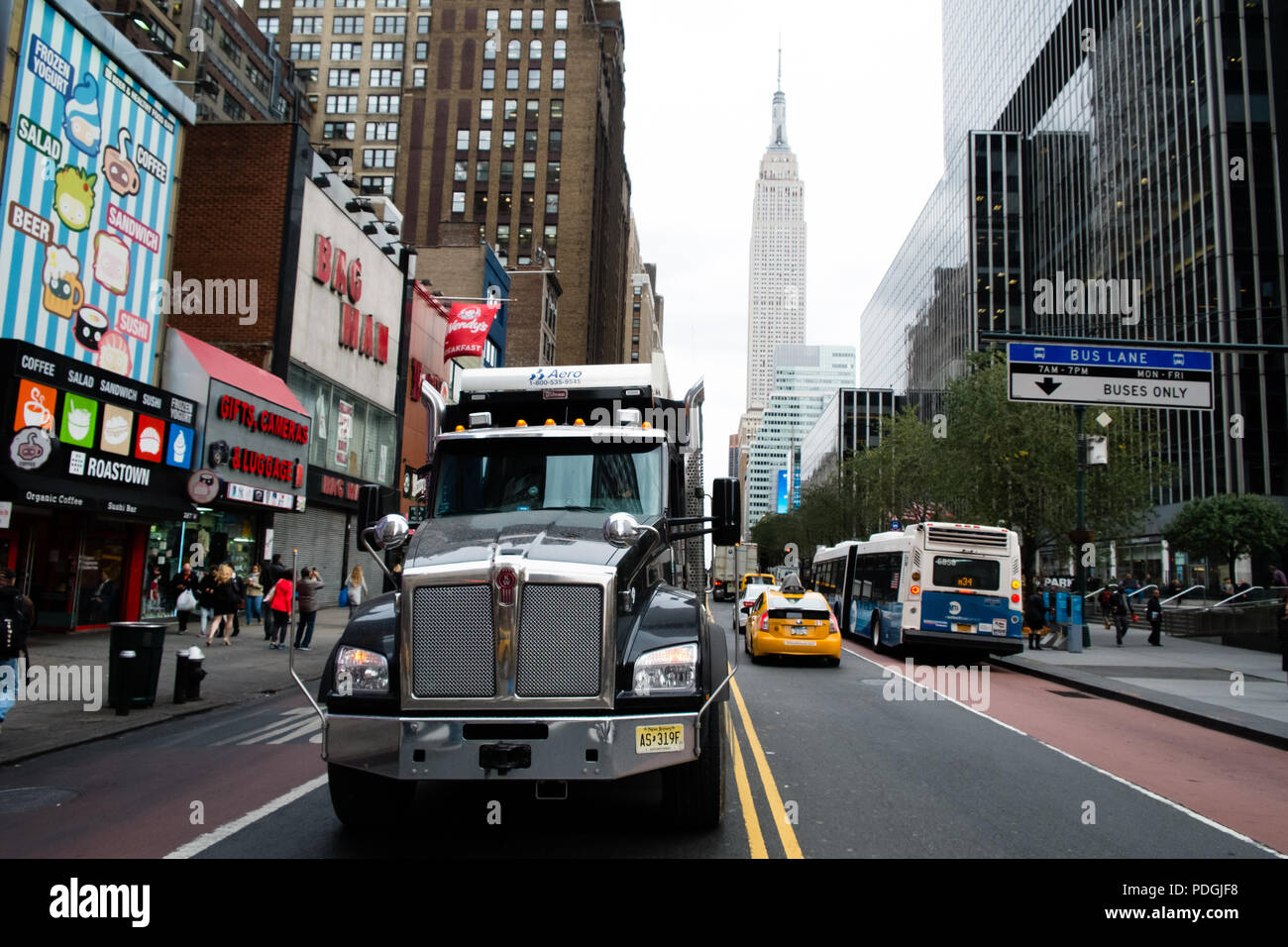 Carretilla en calle de Nueva York, con el Empire State en segundo plano. Foto de stock