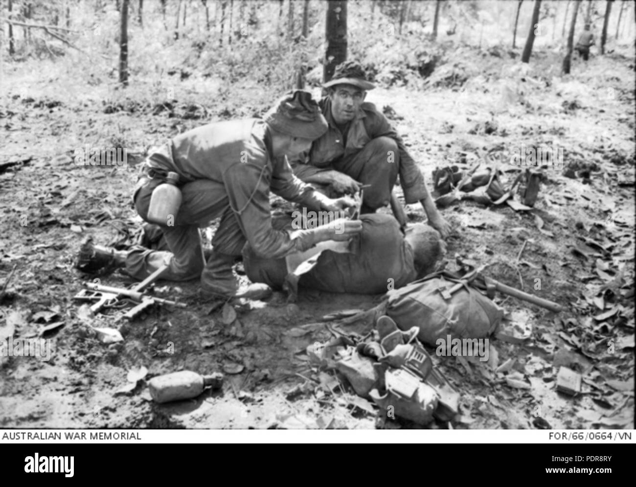 84 Medic la prestación de primeros auxilios a los heridos soldado australiano en Long Tan (AWM PARA660664VN) Foto de stock