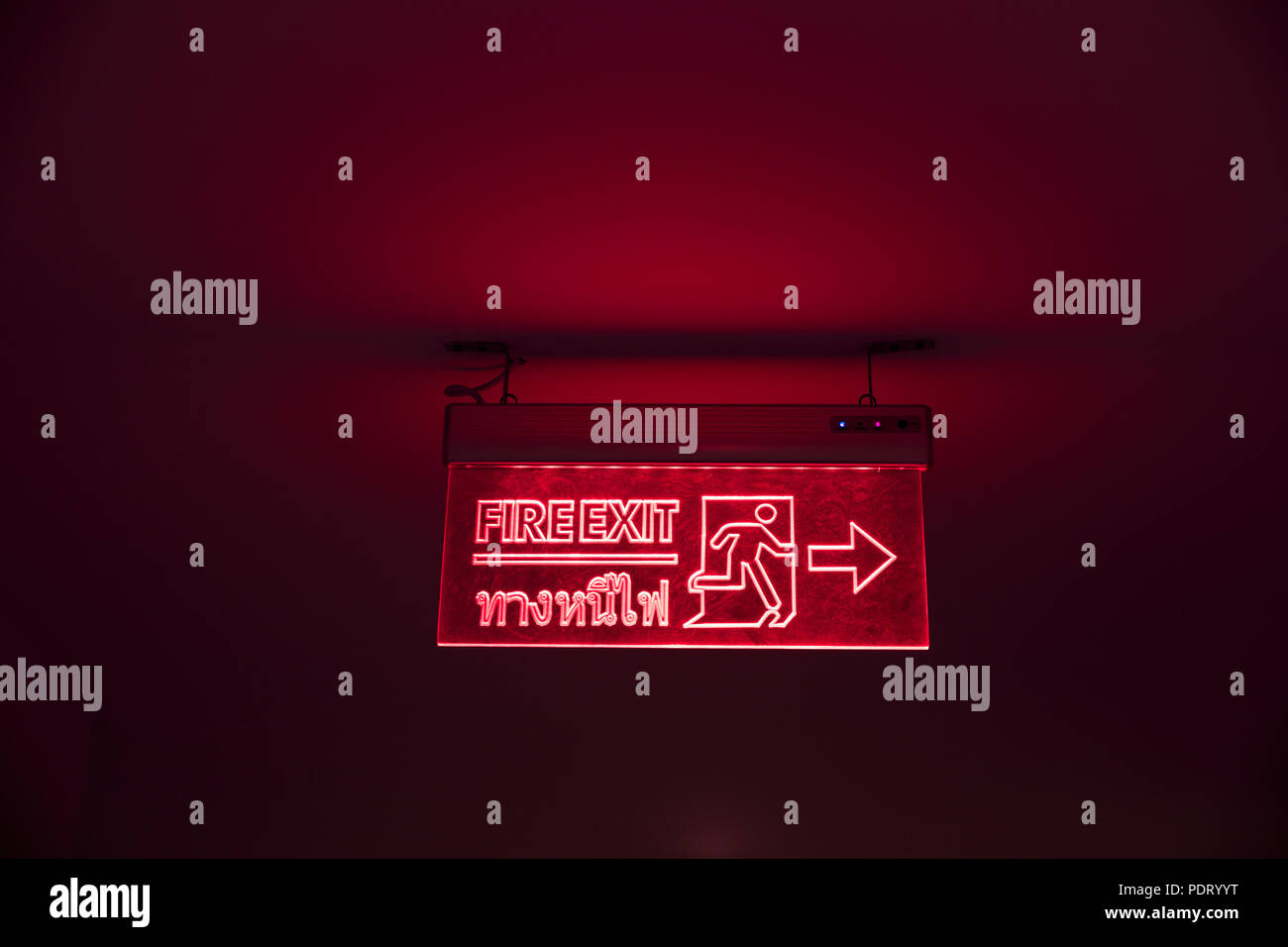 Salida de incendios banner forma de escape de emergencia con idioma tailandés noche rojo oscuro Foto de stock