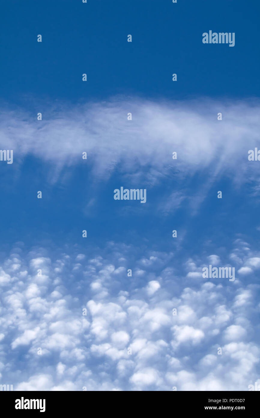 Y entreverado puffy Cirrocúmulos nubes contra el cielo azul. Orientación vertical. Foto de stock