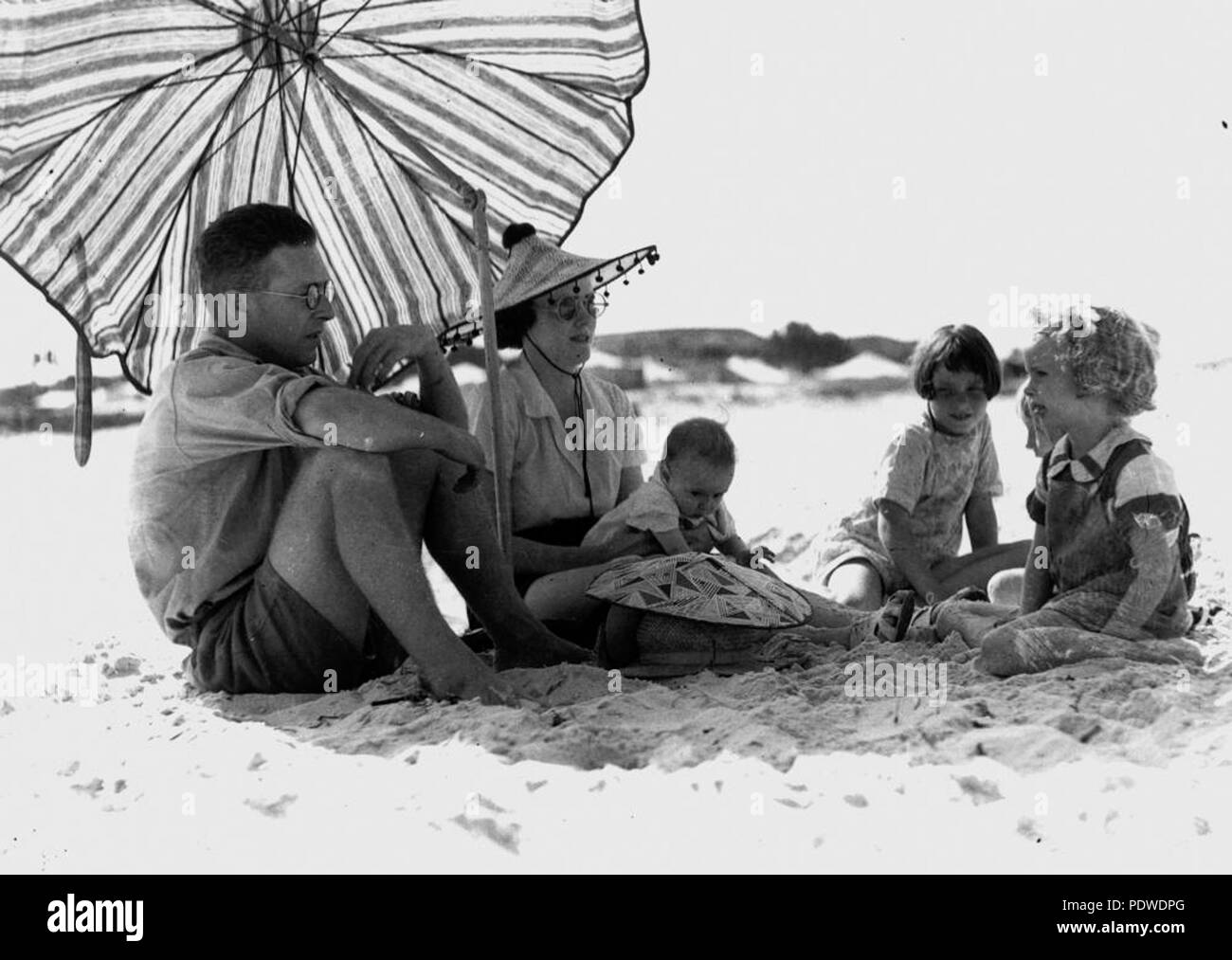 214 1 126527 StateLibQld Sr. y Sra. J. Bell y familia disfrutando de la playa de Burleigh Heads, 1938 Foto de stock