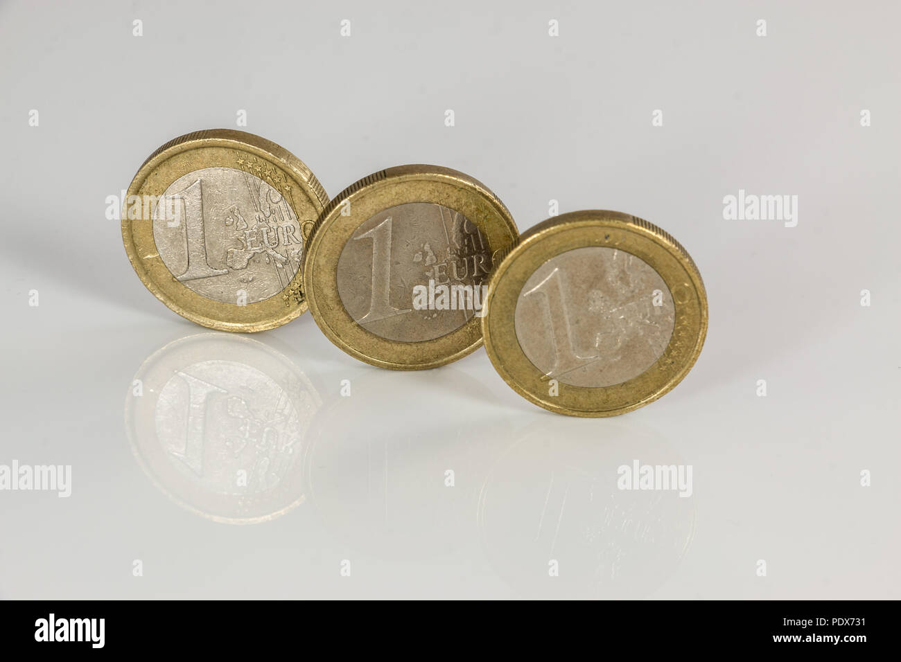 Las monedas de euro sobre fondo blanco con reflejos Foto de stock