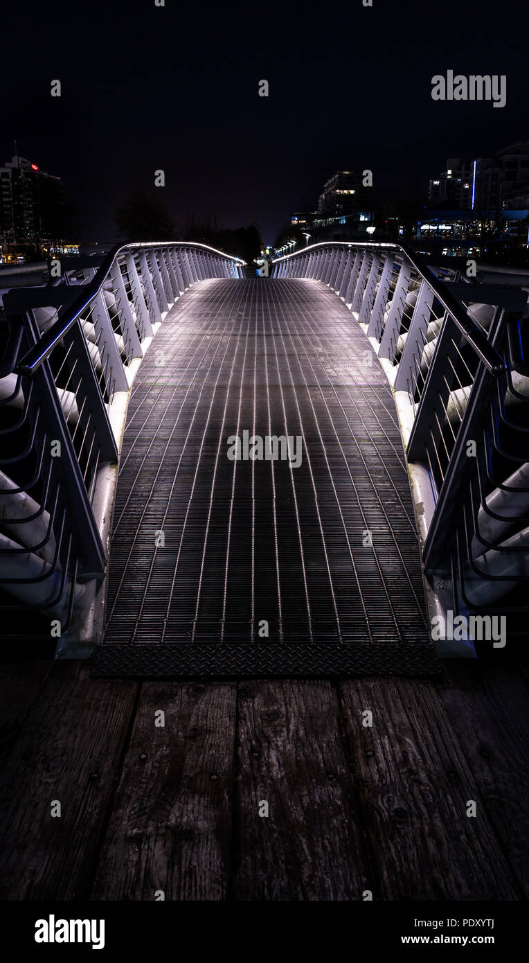 Pequeño puente peatonal en la noche en False Creek, Vancouver. Foto de stock