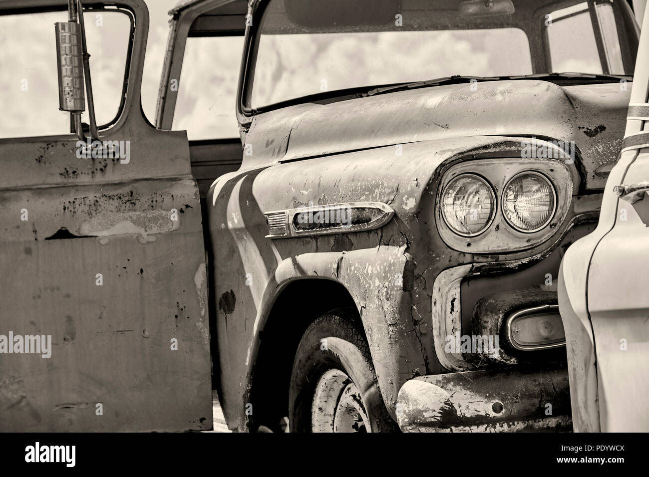 Guardabarros delantero, faros y abrir la puerta del pasajero de una antigua  camioneta vieja oxidada en blanco y negro con poca profundidad de campo  Fotografía de stock - Alamy