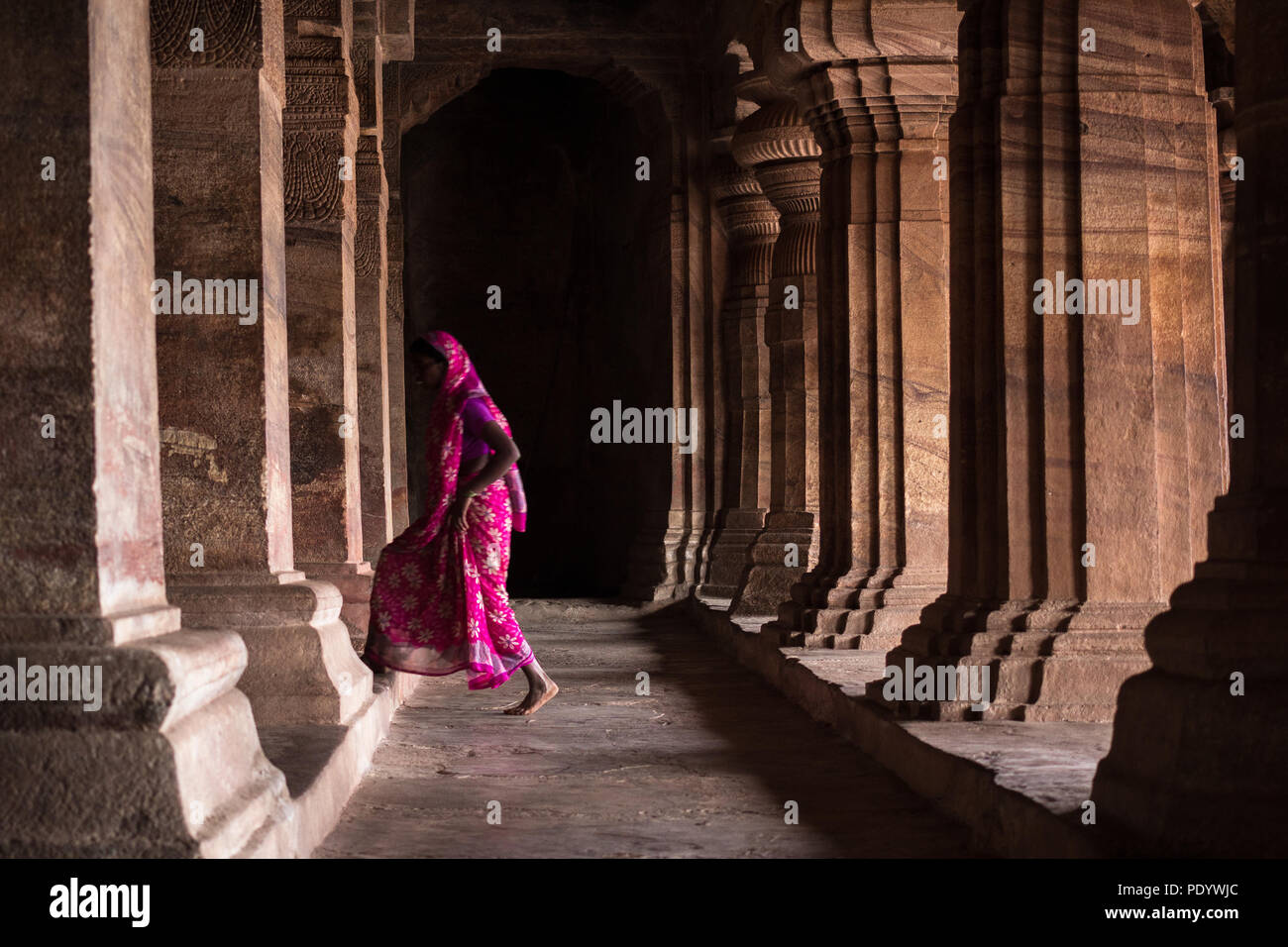 Señora en saree caminando por el templo cueva badami corredor Foto de stock