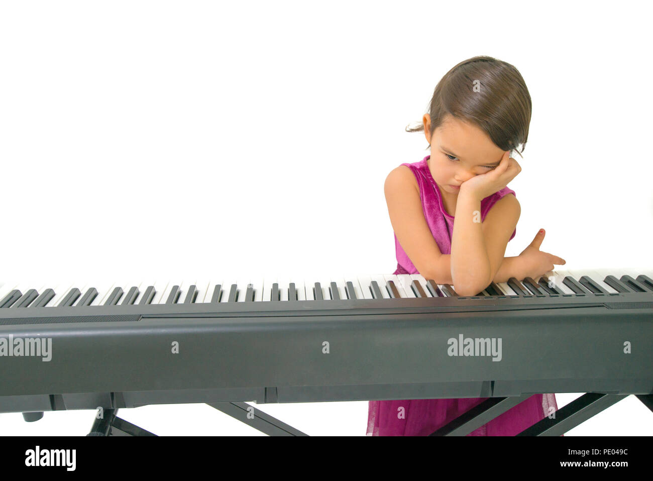 Niña cansados mientras practica el piano Foto de stock