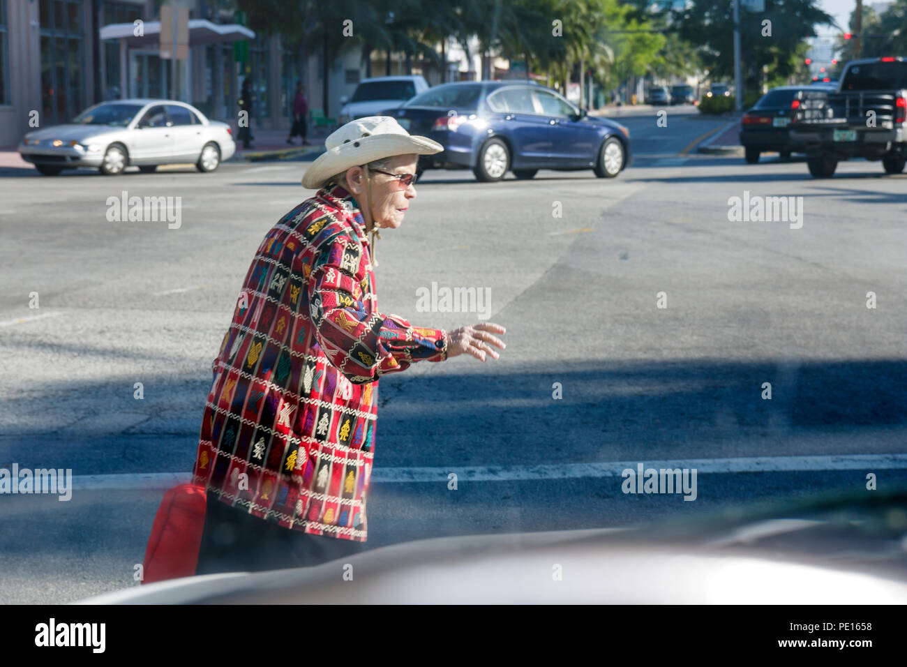 Miami Beach Florida, Washington Avenue, mujeres mujeres, ancianos ciudadanos, cruzar la calle, lento, tráfico, intersección, esquina, vista a través de au Foto de stock